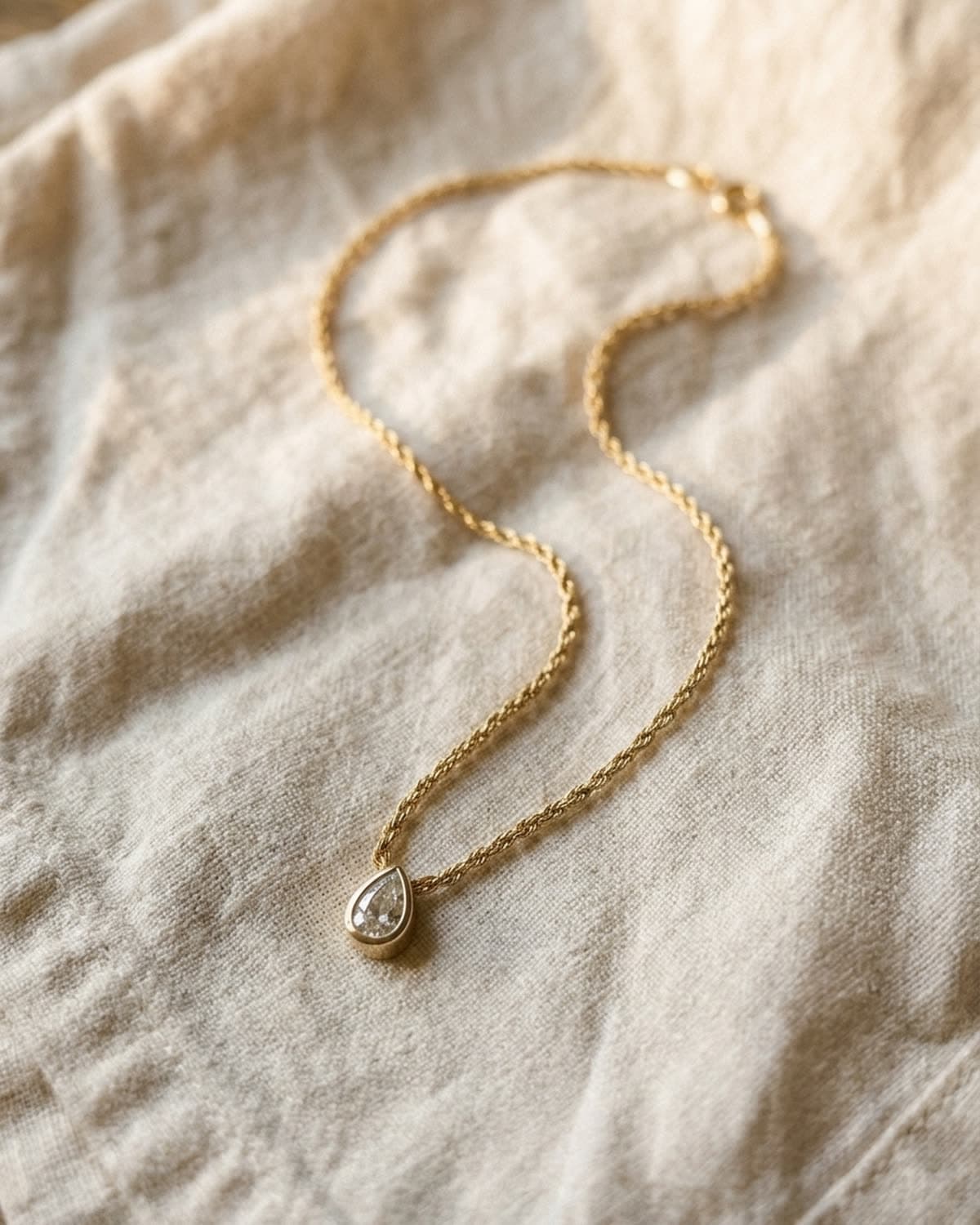 necklace photographed with bling ai — overhead s-curve on linen